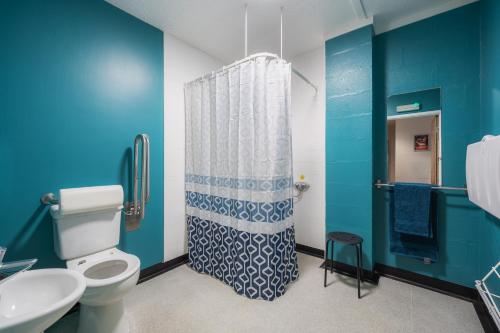 La salle de bains bleue est pourvue de toilettes et d'une douche. dans l'établissement Stunning Rural 72 bed bunkhouse 21 Bedrooms, à Elerch