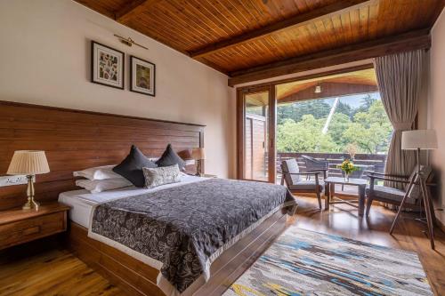 a bedroom with a bed and a large window at Bedzzz Xclusiv Baikunth, Manali By Leisure Hotels - 650 meters from Hidimba Devi Temple in Manāli
