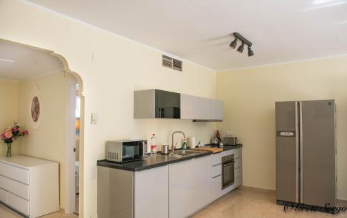 een keuken met witte kasten en een roestvrijstalen koelkast bij Life El Presidente Penthouse Pool View in Estepona