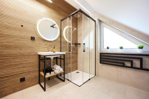 a bathroom with a shower and a sink and a mirror at EveRest Apartamenty Szczyrk in Szczyrk