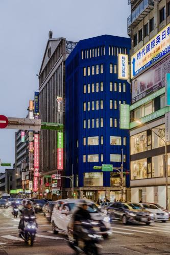 a busy city street with cars and people on motorcycles at The Blue by Just Inn in Taipei