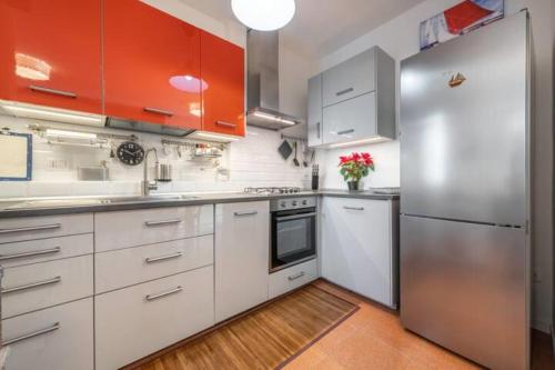 La cuisine est équipée de placards blancs et d'un réfrigérateur en acier inoxydable. dans l'établissement House Roberta - Green Oasis in the City, à Cagliari