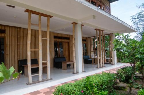 a resort with pillars and chairs on a patio at Rinjani Eco Villa Senaru in Bayan