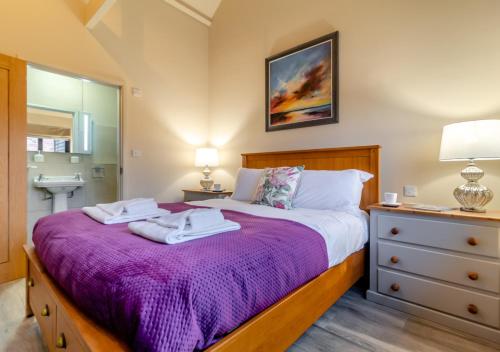 a bedroom with a bed with two towels on it at White House Lodges - Swallow in Heveningham