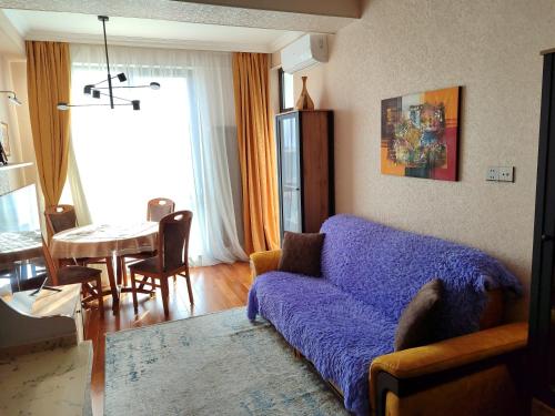 ein Wohnzimmer mit einem blauen Sofa und einem Tisch in der Unterkunft Резиденция Изумруд in Baku
