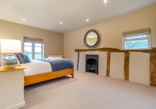 a bedroom with a bed and a mirror on the wall at White House Lodges - Meadow in Heveningham