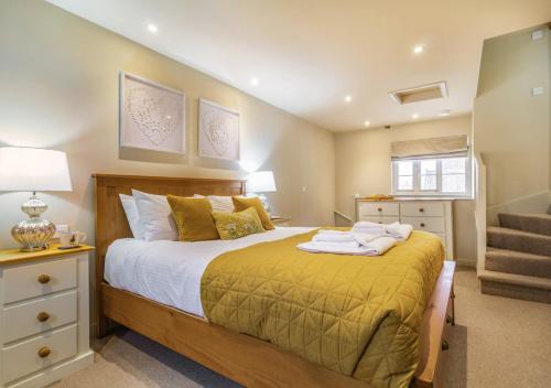 a bedroom with a large bed and a staircase at White House Lodges - Dragonfly in Heveningham