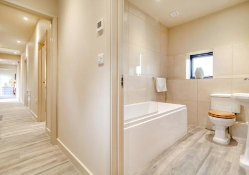uma casa de banho com uma banheira, um WC e um lavatório. em White House Lodges - Nightingale em Heveningham