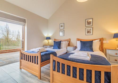 two beds in a bedroom with a balcony at White House Lodges - Napier in Heveningham