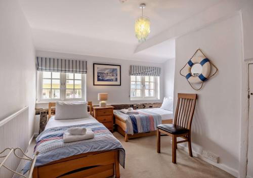 1 dormitorio con 2 camas, escritorio y silla en Orford Cottage en Aldeburgh