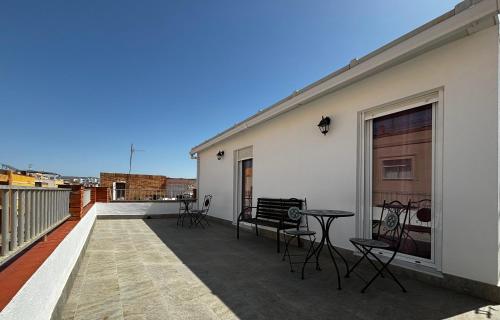 einen Balkon mit Stühlen und einem Tisch auf einem Gebäude in der Unterkunft ALOJAMIENTOS AGAVE in Tabernas