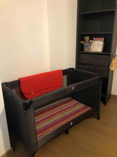 - un petit lit dans une chambre avec une commode dans l'établissement Les Cotonnades (Colmar), à Wintzenheim