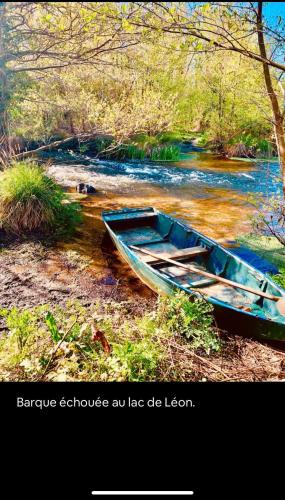 a blue boat sitting on the side of a river at Studio à Linxe entre terre et océan in Linxe