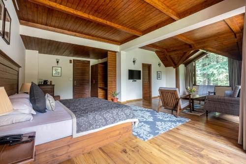 a bedroom with a large bed and a wooden ceiling at Bedzzz Xclusiv Baikunth, Manali By Leisure Hotels - 650 meters from Hidimba Devi Temple in Manāli