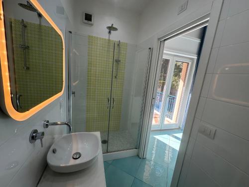 a white bathroom with a shower and a sink at Il Sirenio in Sorrento
