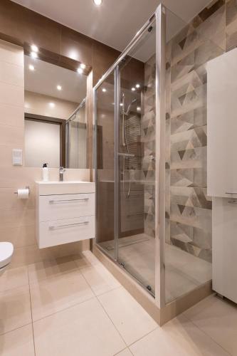 a bathroom with a shower and a toilet and a sink at Apartamenty City Tower od WroclawApartament-pl in Wrocław