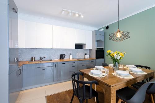 a kitchen with a wooden table and a dining room at Apartamenty City Tower od WroclawApartament-pl in Wrocław