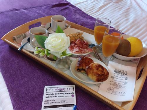 a tray of breakfast foods and drinks on a table at Hotel Playa Ribera in Suances