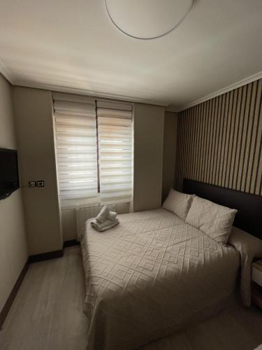 a bedroom with a bed with a hat on it at Alojamientos Rooms Catamarán in Castro-Urdiales