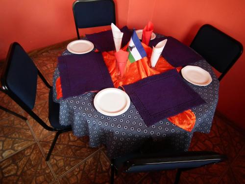 una mesa con platos y servilletas en la parte superior en Ribaneng Lodge en Ribaneng