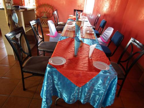 a long table in a restaurant with a blue table cloth at Ribaneng Lodge in Ribaneng