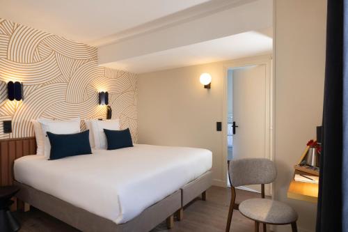 Habitación de hotel con cama blanca y silla en Bijou Hôtel Paris Boulogne, en Boulogne-Billancourt