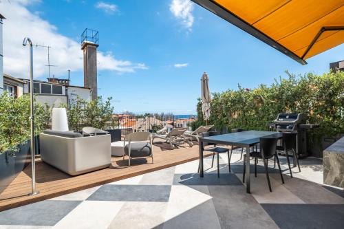 a patio with a table and chairs on a roof at Exclusive Terrace Apartment at Savoy Insular in Funchal