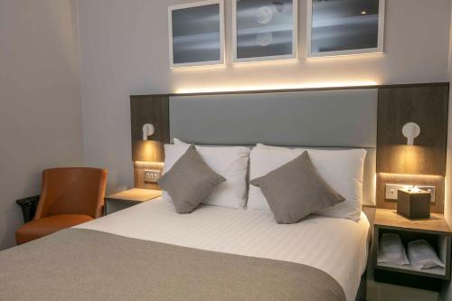 a bedroom with a bed with white sheets and pillows at Best Western Plus Vauxhall Hotel in London