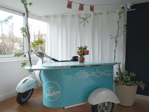 Un scooter azul y blanco con un carro en una habitación en Hotel Playa Ribera, en Suances