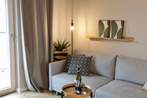 een woonkamer met een bank en een fles wijn op een tafel bij Capital Towers Prime in Rzeszów