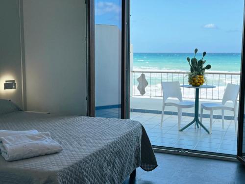 a bedroom with a bed and a view of the ocean at Hotel La Battigia in Alcamo Marina