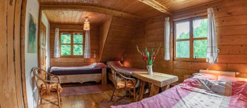 a room with two beds and a table in a cabin at U Prezesa in Lutowiska