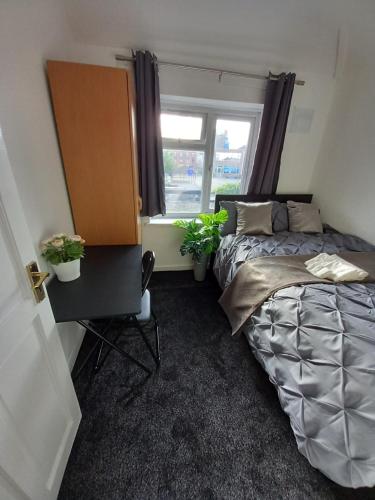 1 dormitorio con cama y ventana en JosteeStay Apartments -Rooms en Goodmayes