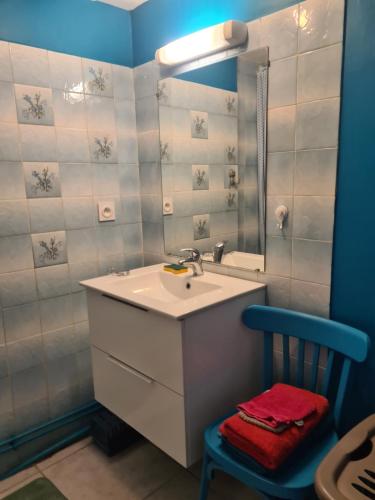 a bathroom with a sink and a mirror and a chair at Gite de la Rowa Monthermé in Monthermé