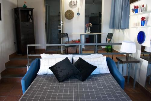 una cama con almohadas en una habitación en Casetta Licciardello, en Trecastagni