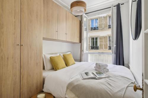 - une chambre avec un lit et un livre dans l'établissement Central Paris - Le Marais - CityApartmentStay, à Paris