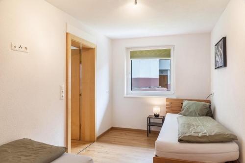 a small bedroom with a bed and a window at Haus Florian Ski-in and Ski-out in See