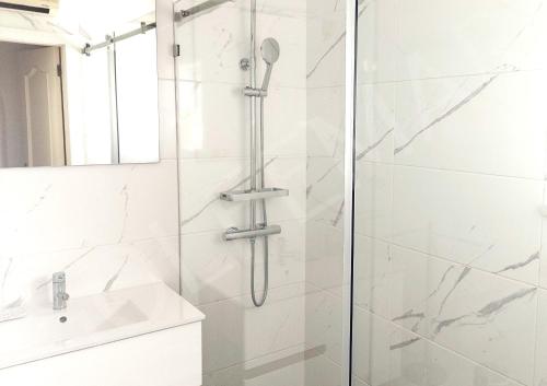 una ducha con una puerta de cristal junto a un lavabo en Vila Golfemar, en Carvoeiro