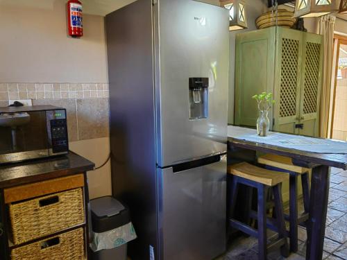 eine Küche mit einem Kühlschrank aus Edelstahl und einer Theke in der Unterkunft Teas & Seas Self Catering Cottage in Kapstadt