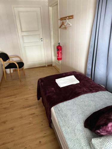 a room with a bed and a fire extinguisher at Storfossen Hostel in Gratangen