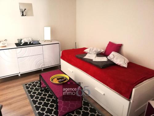 a small room with a bed with a red blanket at Résidence Pyrénées Zenith in Luz-Saint-Sauveur