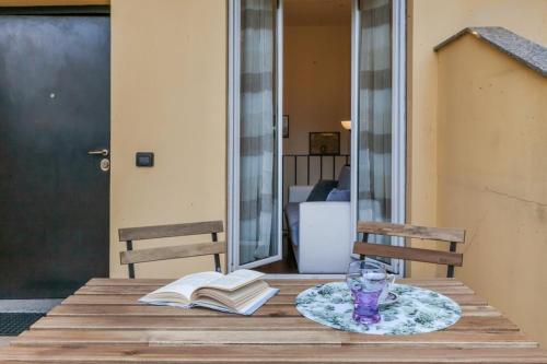 uma mesa com um livro e um copo e um livro em VILLA POLLICINO - outdoor patio, 10-minute walk to metro em Milão