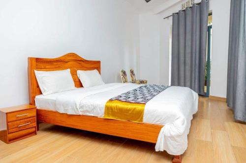 a bedroom with a large bed with a wooden headboard at Ruhondo Beach Resort in Ruhengeri