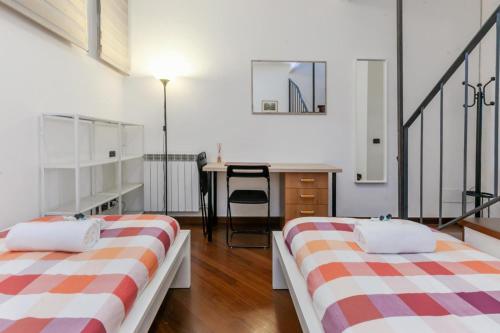 Cette chambre comprend 2 lits et un bureau. dans l'établissement VILLA POLLICINO - outdoor patio, 10-minute walk to metro, à Milan