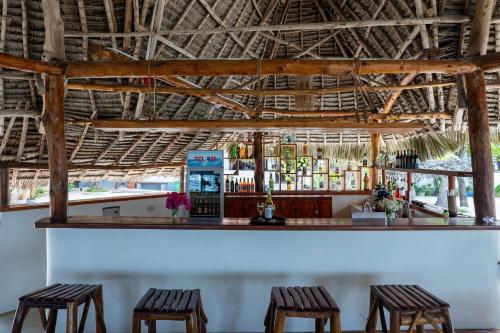 a bar with two stools and a drink machine at MANOLO Beach Resort in Uroa