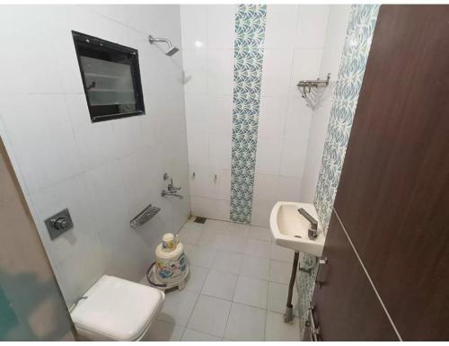 a small bathroom with a toilet and a sink at Shreeji Farm and Resort, Jalondar, Gujarat in Chāndawāri