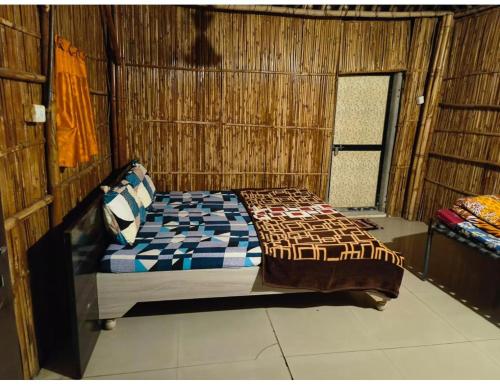 1 dormitorio con 1 cama en una pared de madera en Shreeji Farm and Resort, Jalondar, Gujarat, en Chāndawāri