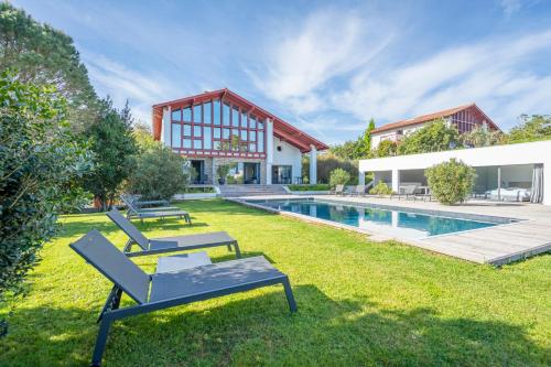 a yard with two chairs and a swimming pool at Lafitenia Resort in Saint-Jean-de-Luz