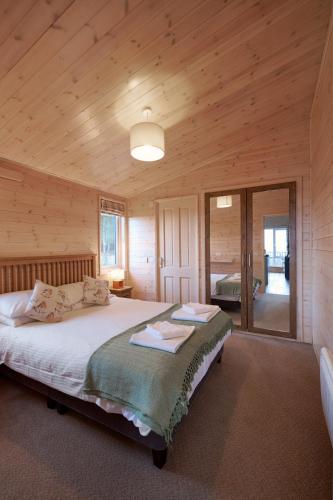 a bedroom with a bed in a wooden cabin at Burgie Woodland Lodges in Forres