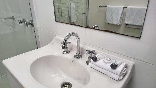 lavabo blanco en el baño con espejo en KooWeeRup Motel, en Koo-Wee-Rup
